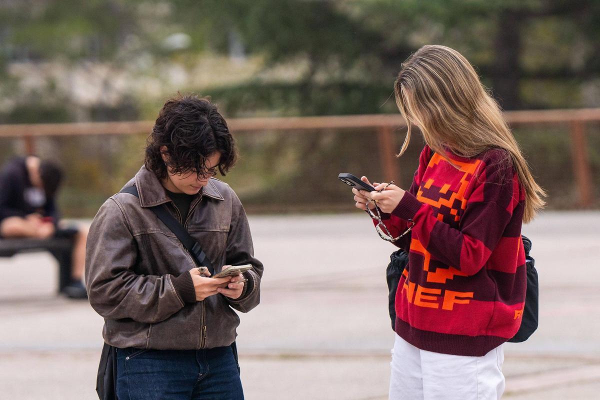 Dos chicas, con sus móviles