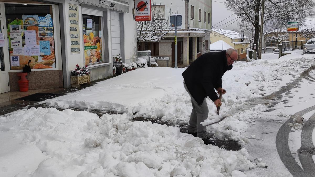 Un vecino del Concello ourensano de San Xoán de Río se afana en retirar el manto de nieve a los pies de su negocio.