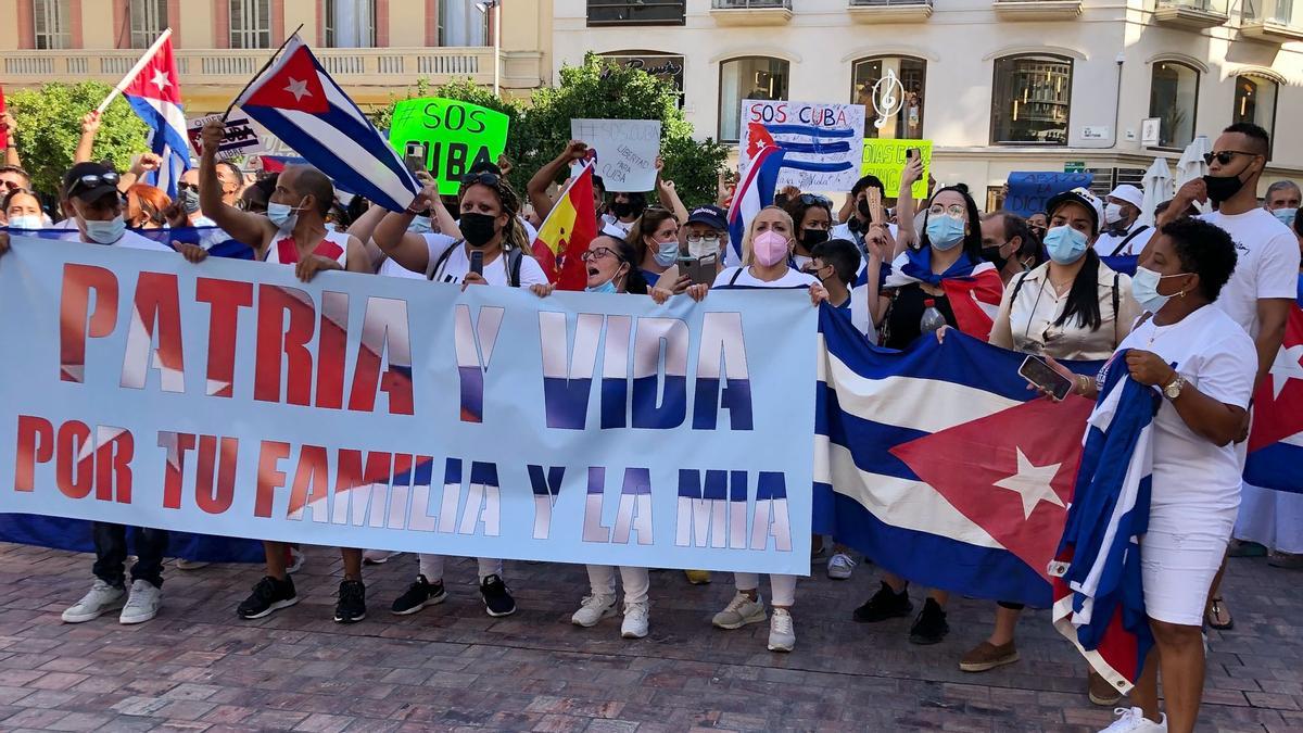 Varias personas manifestándose con una pancarta en la plaza de la Constitución