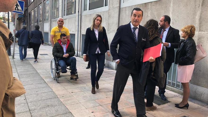 El conductor, Omar López, en silla de ruedas, precedido de su esposa y su letrado, Víctor Tartiere, a su llegada a los Juzgados de Avilés.