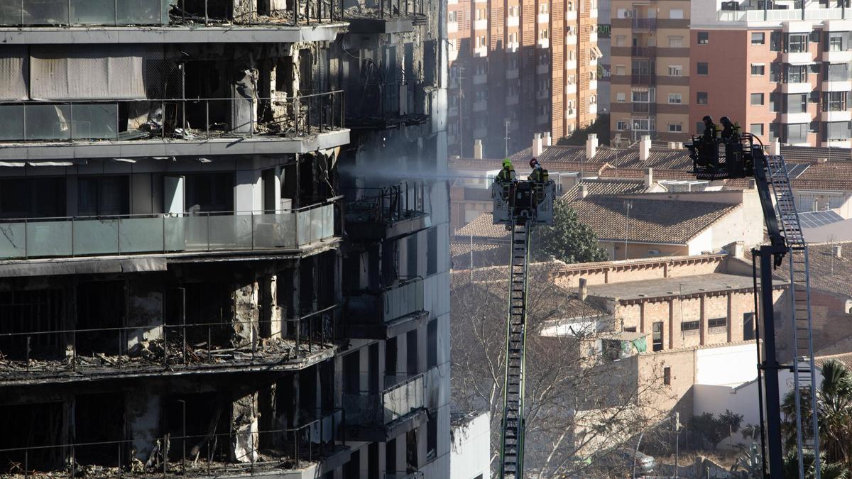 Los bomberos continúan refrescando el edificio incendiado en Campanar