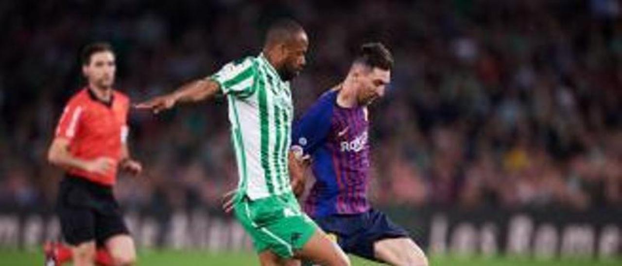 Sidnei persigue a Messi, al que trata de arrebatar el balón, en un partido entre el Real Betis y el FC Barcelona. | | LP/DLP