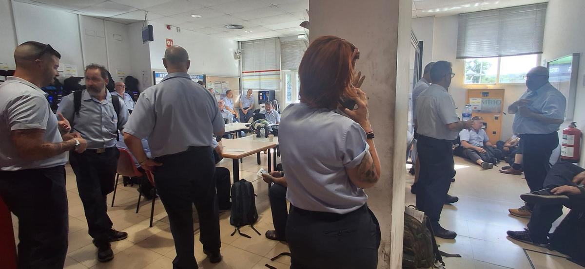 Varios conductores, ayer, esperando instrucciones tras la avería de su autobús.
