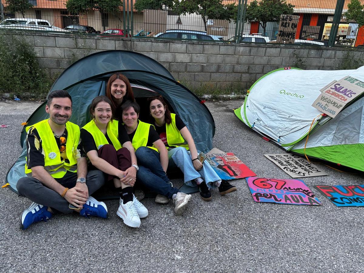 Docentes descansan en una tienda de campaña en el patio.
