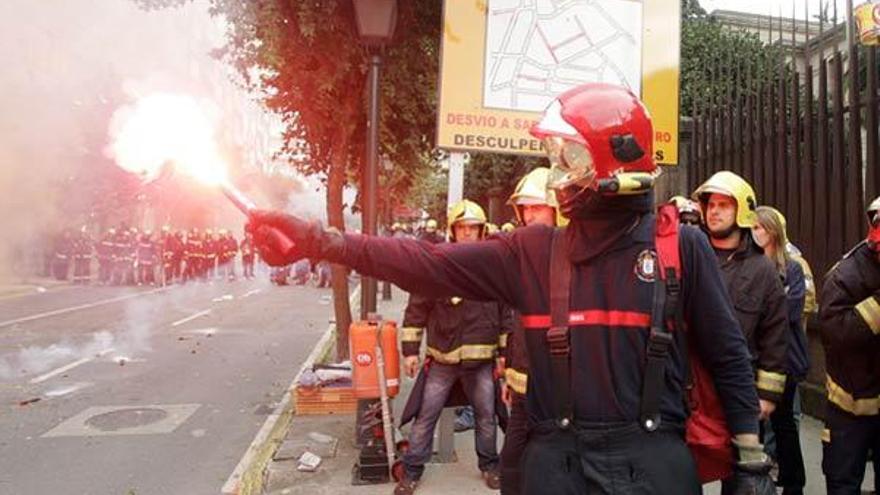 Un bombero sostiene una bengala.  // X. A.