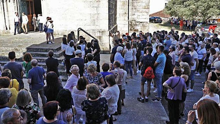 Decenas de personas siguen el funeral desde el exterior de la iglesia de Santiago en Redondela.