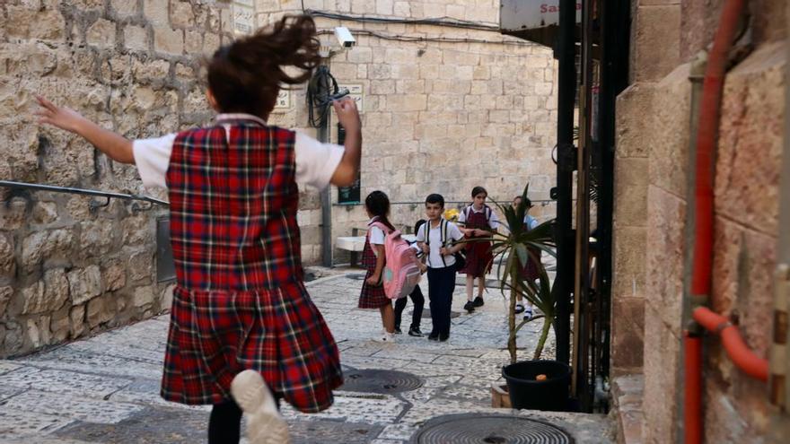 Niños palestinos corretean por el barrio cristiano de la ciudad vieja de Jerusalén a la salida del colegio.