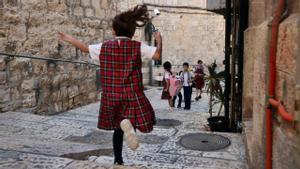 Niños palestinos corretean por el barrio cristiano de la ciudad vieja de Jerusalén a la salida del colegio.