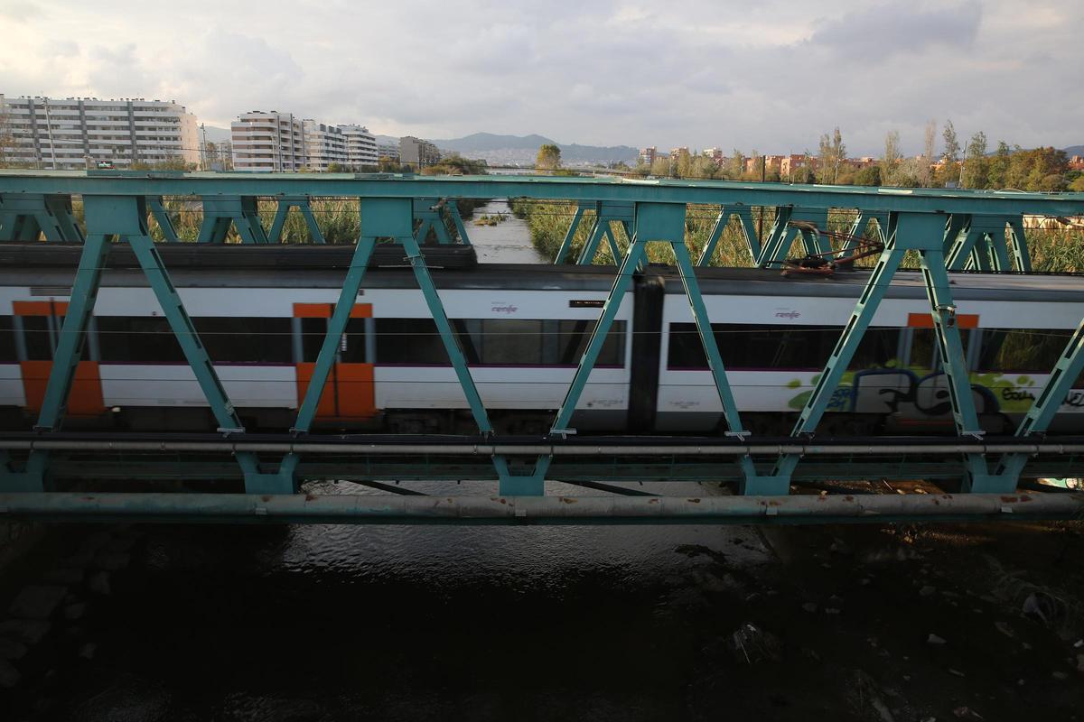 Un tren de Rodalies atraviesa el puente del ferrocarril sobre el río Besòs, en Sant Adrià.