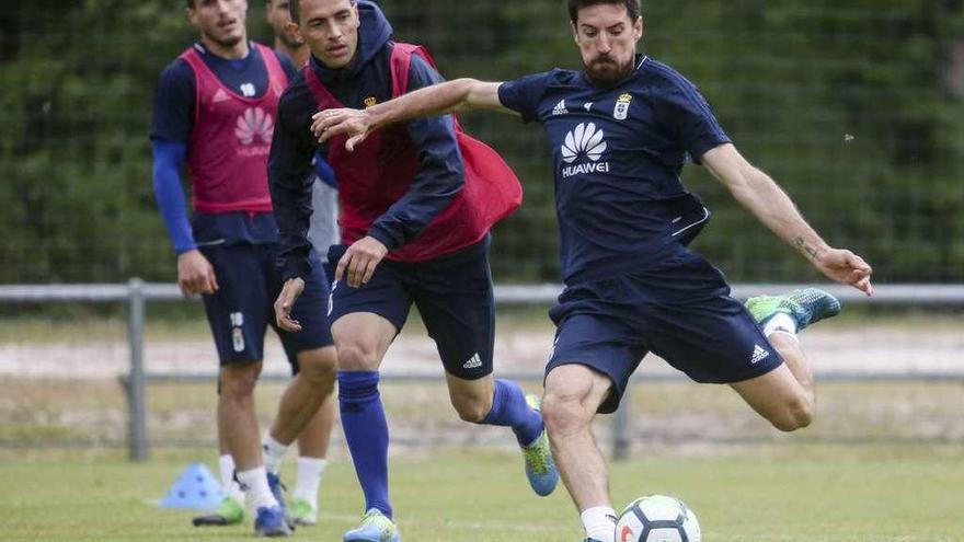 Toché dispara con la zurda ante la presión de Rocha y la mirada de Christian en el entrenamiento de ayer.