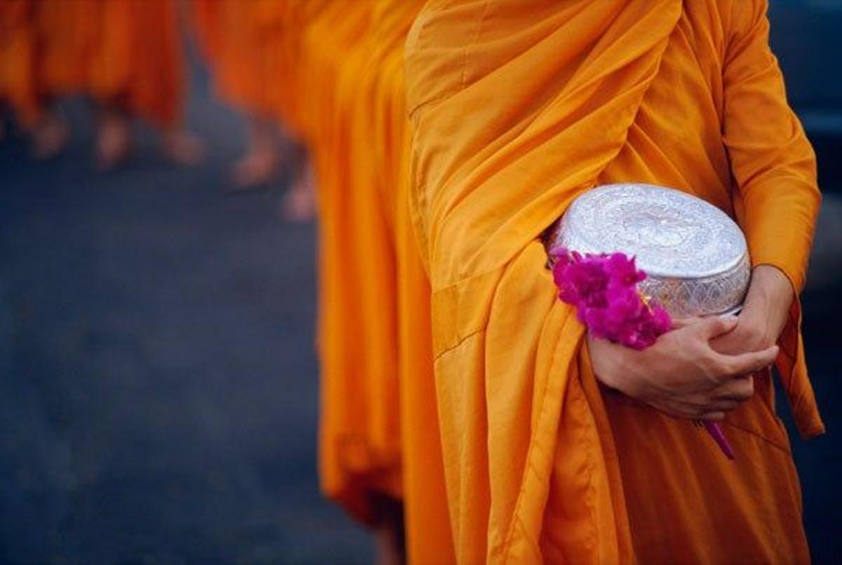Monjes budistas realizando una ofrenda en el templo Wat Benchamabopit o Templo de Mármol, en Bangkok, Tailandia.