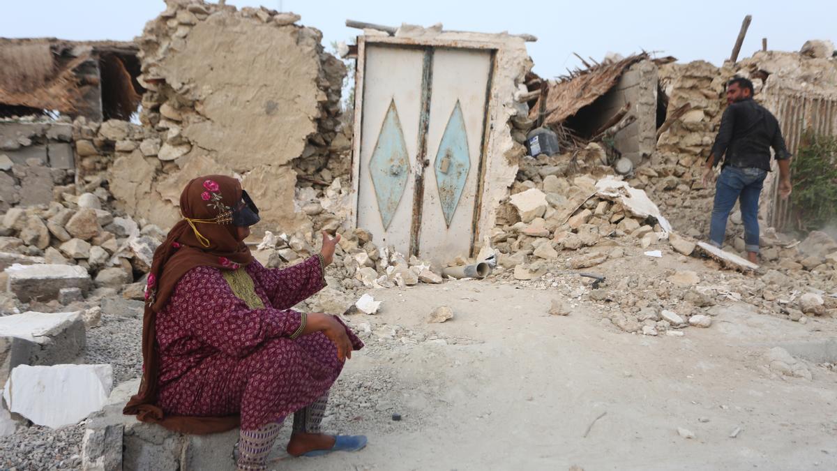 Una mujer sentada frente a los escombros de su casa tras un fuerte terremoto, en la aldea de Sayeh Khosh, provincia de Hormozgan, sur de Irán.