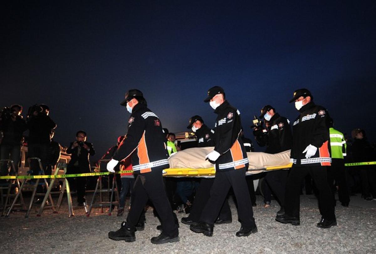 Equips de rescat traslladen pel port de Jinbo el cos d’una de les víctimes de l’enfonsament del ’Sewol’.