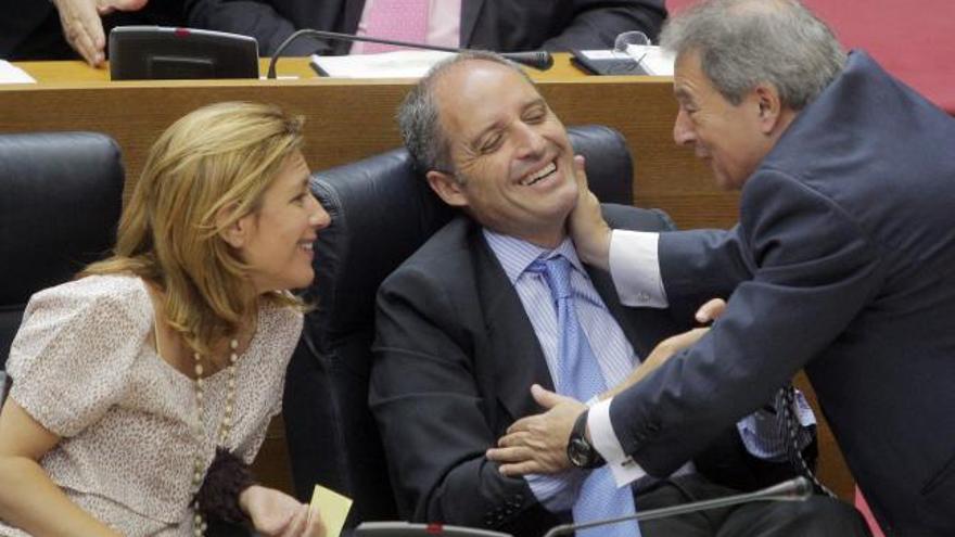 El president de la Generalitat, Francisco Camps, bromea con el diputado y presidente de la diputación, Alfonso Rus, y con la vicepresidenta, Paula Sánchez de León, durante el pleno.