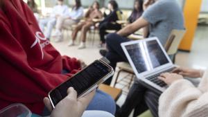 Un estudiante busca información en su móvil a la hora del patio en un instituto catalán.