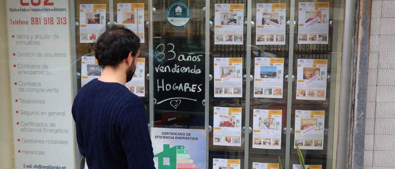 Un hombre mira anuncios de viviendas en una inmobiliaria de A Coruña.