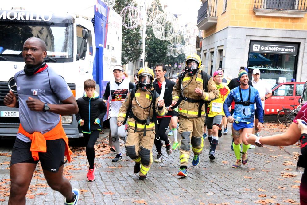 Dos bombers durant la 12a Marató per La Marató organitzada pel Club d’Atletisme, els Bombers i l’Ajuntament de Girona.