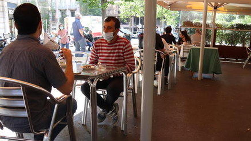 Un grup de persones assegudes a la terrassa d&#039;un bar a la la Rambla de Catalunya