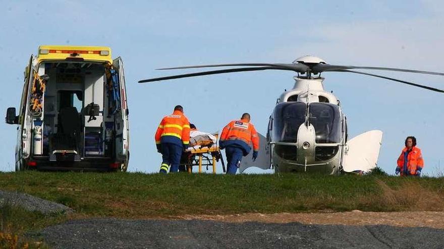 Efectivos sanitarios efectúan el trasbordo del herido grave ayer en Filloi desde la ambulancia al helicóptero. // Bernabé / Adrián Rei