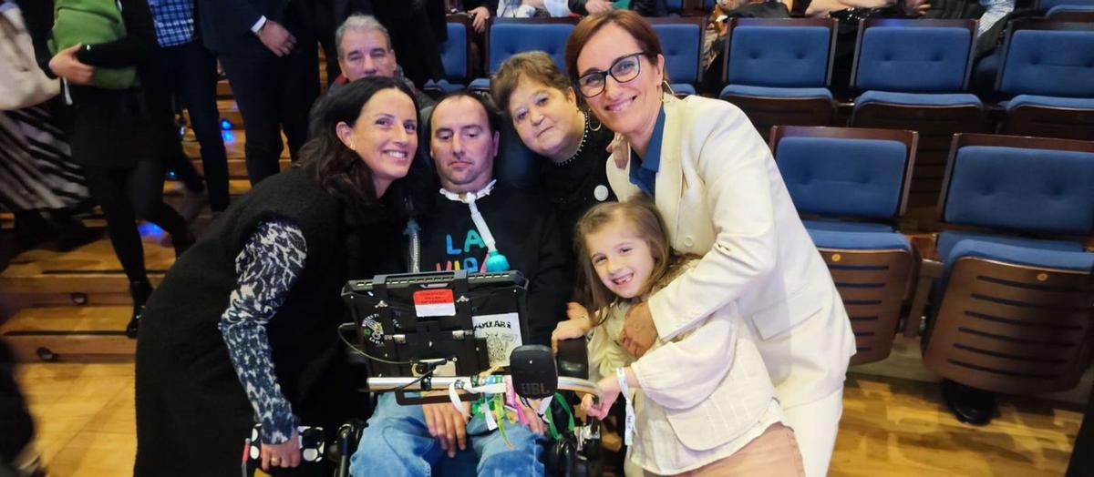 Mónica García, a la derecha, con José Luis Capitán, enfermo de ELA; su esposa, Teresa Pérez; su hija Julia, y la presidenta de ELA Asturias, María José Álvarez, ayer, en el Auditorio Príncipe Felipe. | DAVID CABO