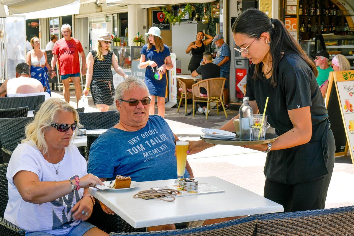 Dos turistas disfrutan de un aperitivo en un establecimiento de la zona