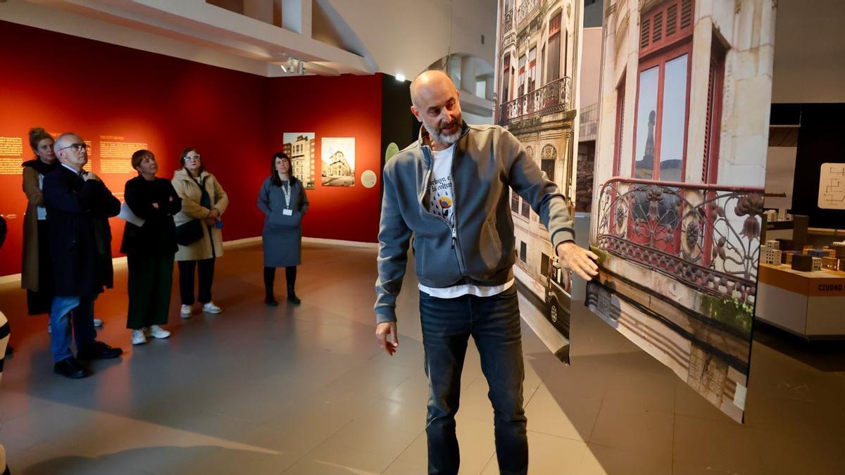 David Alonso, ofreciendo una visita guiada a la exposición este viernes; a su izquierda, Antón García y Semíramis González, junto a otros asistentes, siguiendo sus indicaciones.