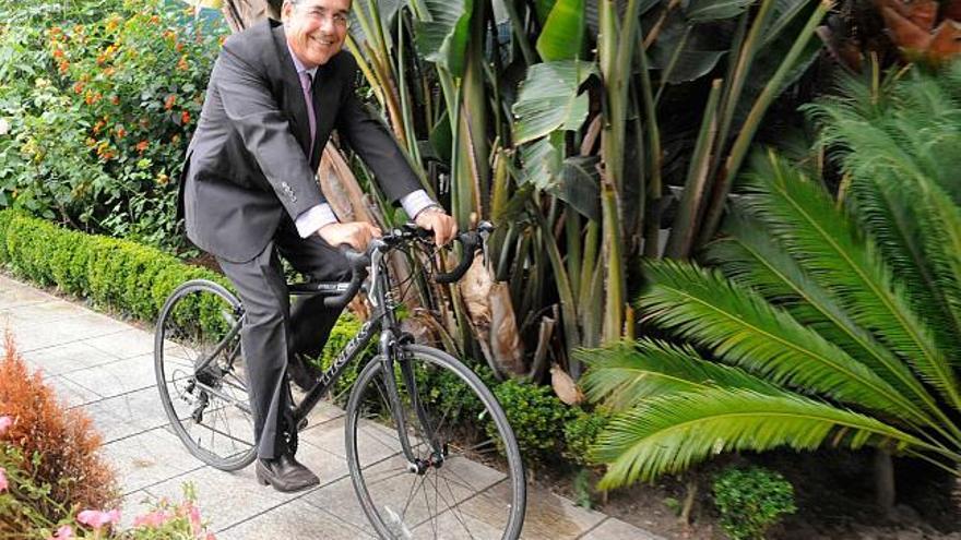 Enrique Rajoy, montado en su bicicleta de carreras, en el jardín de su casa de A Coruña. / víctor echave