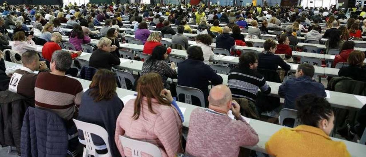 Aspirantes totalmente juntos hacen el examen en uno de los pabellones del recinto ferial.