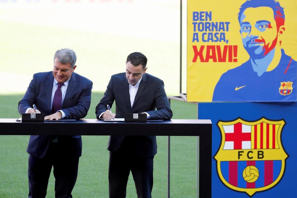 FC Barcelona’s new head coach, Xavi Hernandez (R), signs his contract next to FC Barcelona’s President, Joan Laporta, during his presentation at Camp Nou stadium in Barcelona, Spain, 08 November 2021. Xavi Hernandez left Al-Sadd club of Qatar to lead FC Barcelona for the rest of the current season and two more seasons. EFE/ Alejandro Garcia