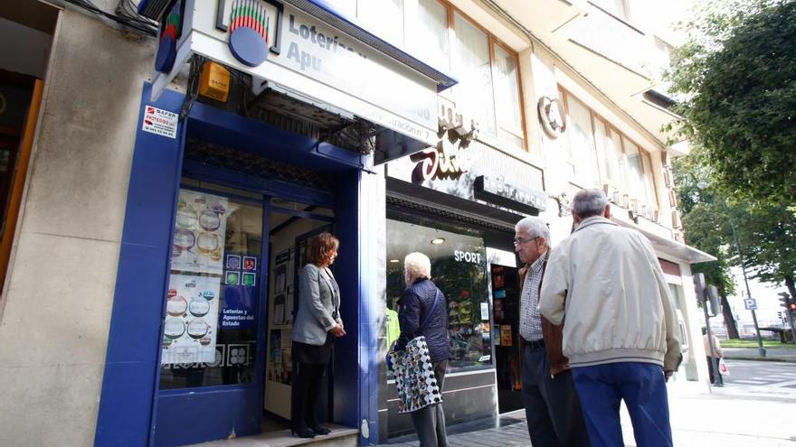 Clientes delante de la administración de lotería que recogió la apuesta premiada.