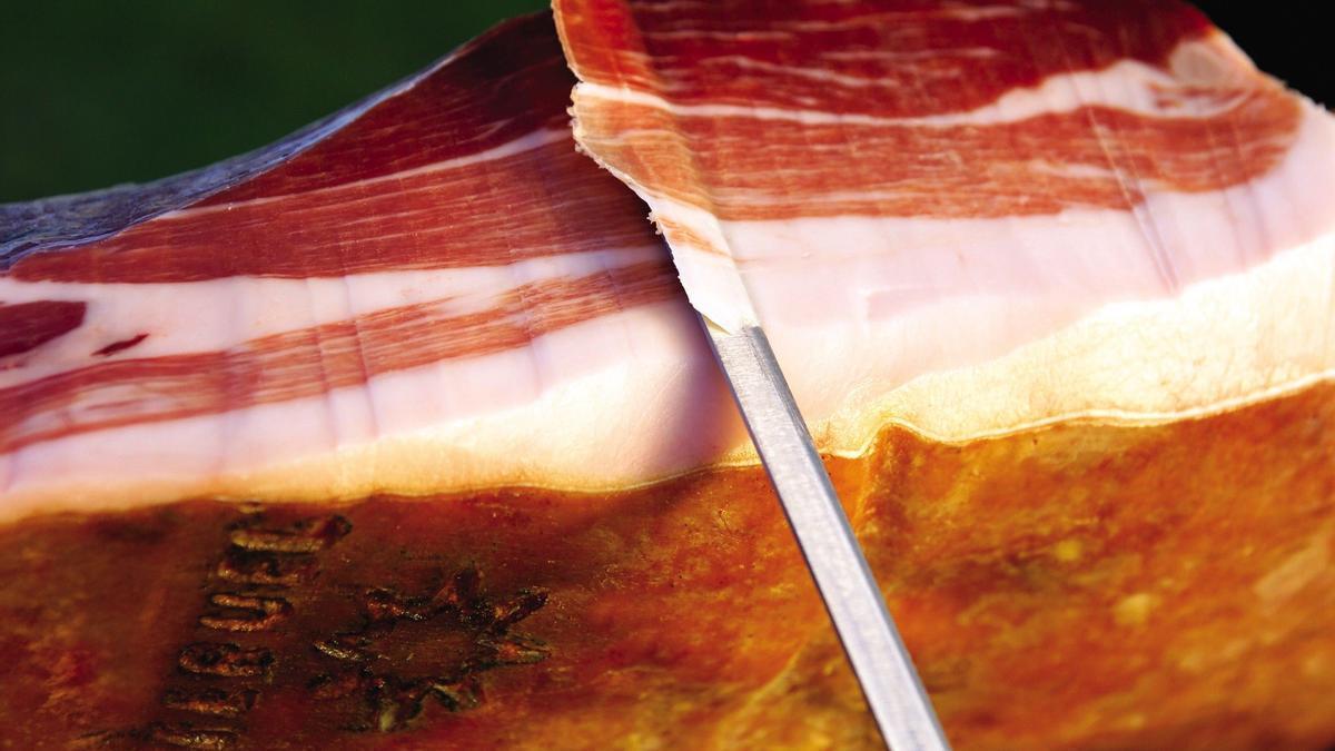 Imagen de archivo de una persona cortando jamón de Teruel