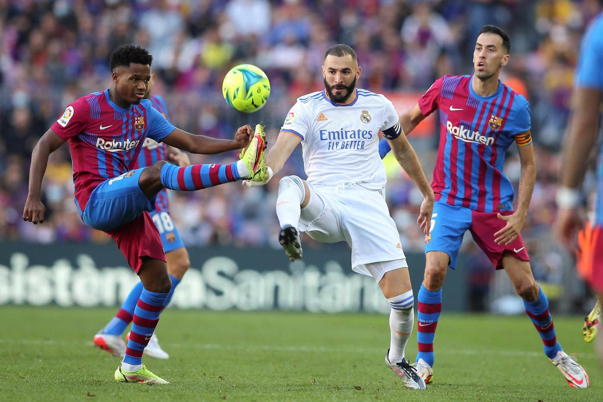 El culé Ansu Fati pelea por el balón con el madridista Karim Benzema ante la mirada de Sergio Busquets en el último Clásico de LaLiga