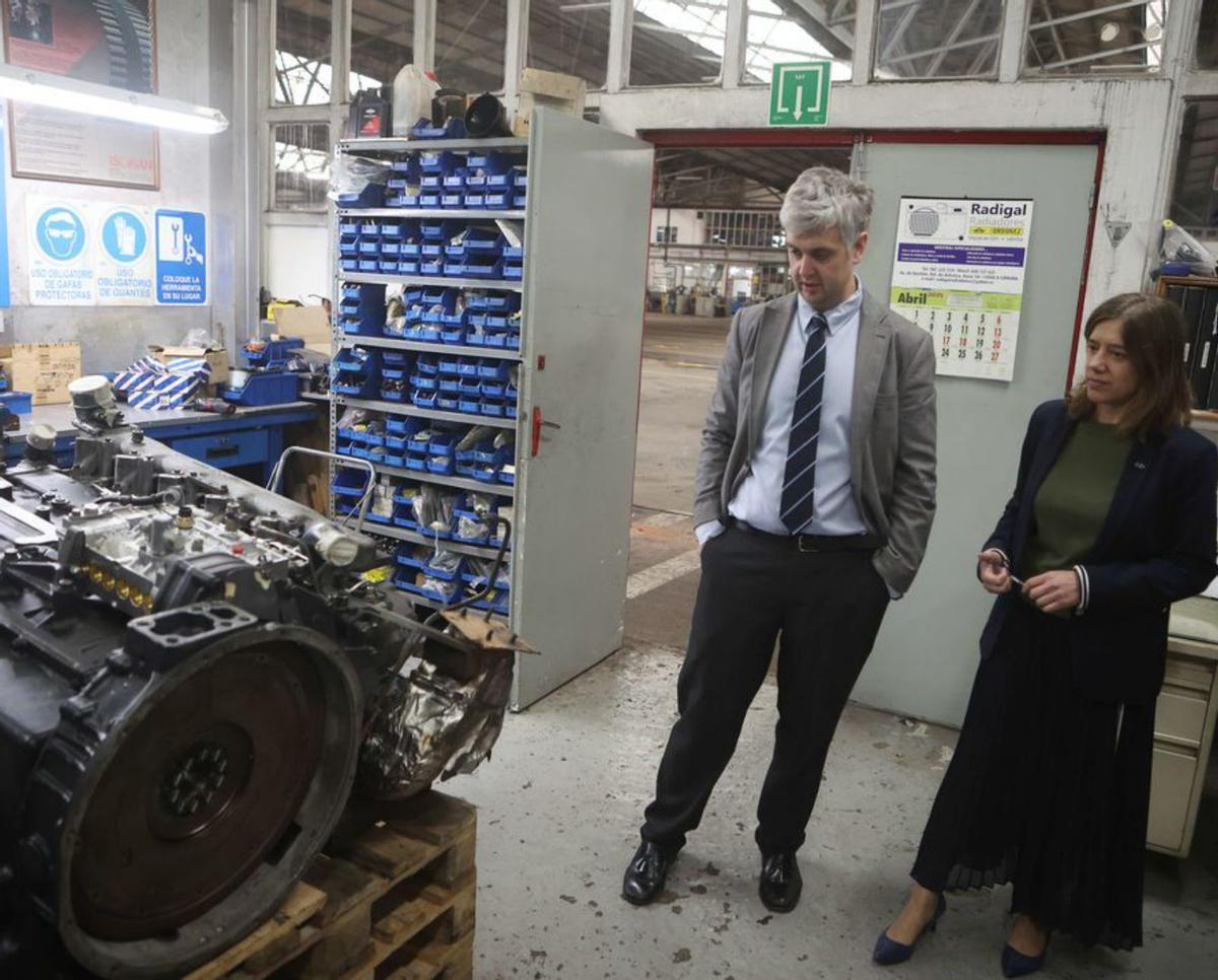 El director y la vicepresidenta de Tranvías, ante un motor de bus en reparación en un taller de la empresa. | | IAGO LÓPEZ