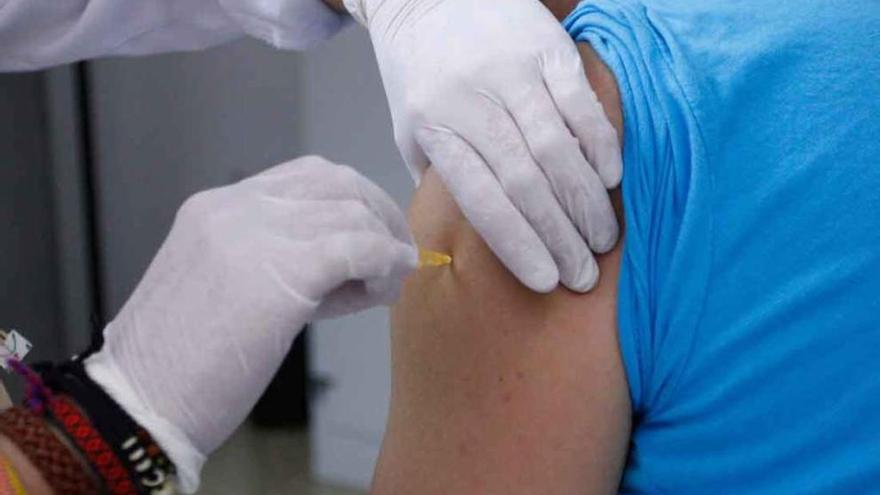 Una enfermera aplica una dosis de vacuna a un paciente.