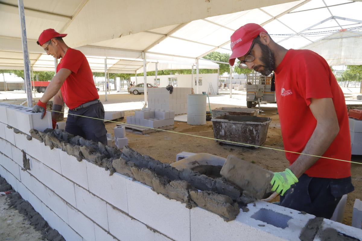 José Antonio Pérez y su compañero levantan un muro.