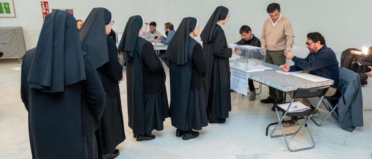 Varias monjas guardan cola para ejercer su derecho al voto en un colegio electoral.