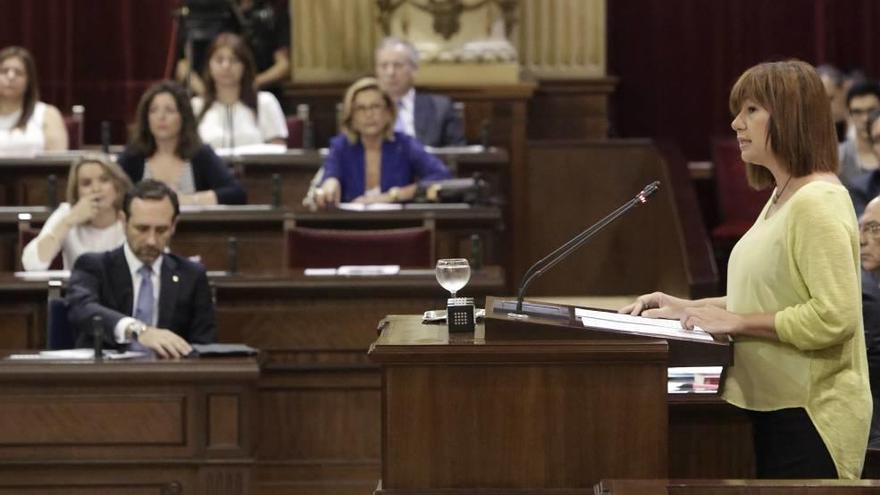 Armengol durante su discurso de investidura. Al fondo, Bauzá ordena sus papeles.