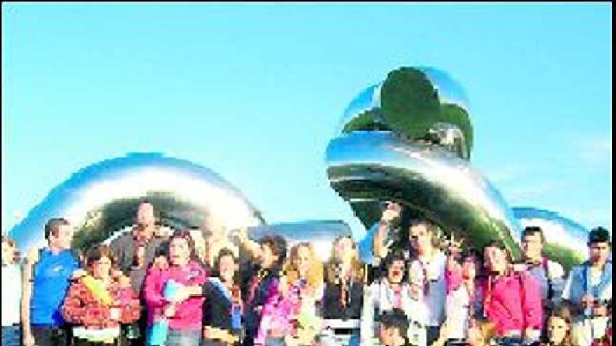 Scouts de La Calzada, ante la escultura «Solidaridad».