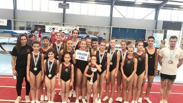 Gimnastas del Sieiro, entre sus entrenadores, Sara Penedo e Iván Estévez.