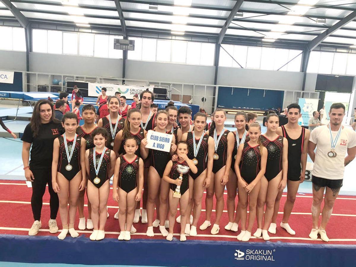 Gimnastas del Sieiro, entre sus entrenadores, Sara Penedo e Iván Estévez.