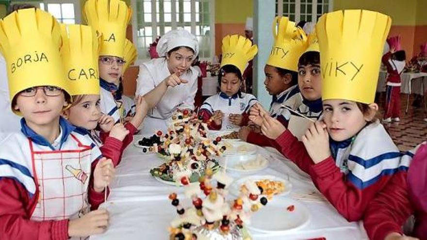 A la izquierda, escolares del Patronato San José, junto a las brochetas con forma de «oricio» que montaron. A la derecha, algunos de los alumnos que realizaron la macedonia de frutas.