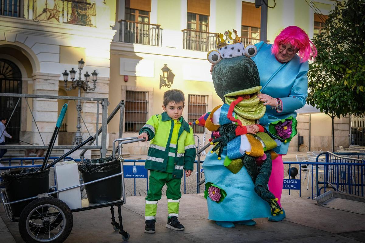 Iker y Jimena junto a su madre disfrazados de barrendero y sapo en el concurso de disfraz en la calle de Badajoz hoy en Plaza España