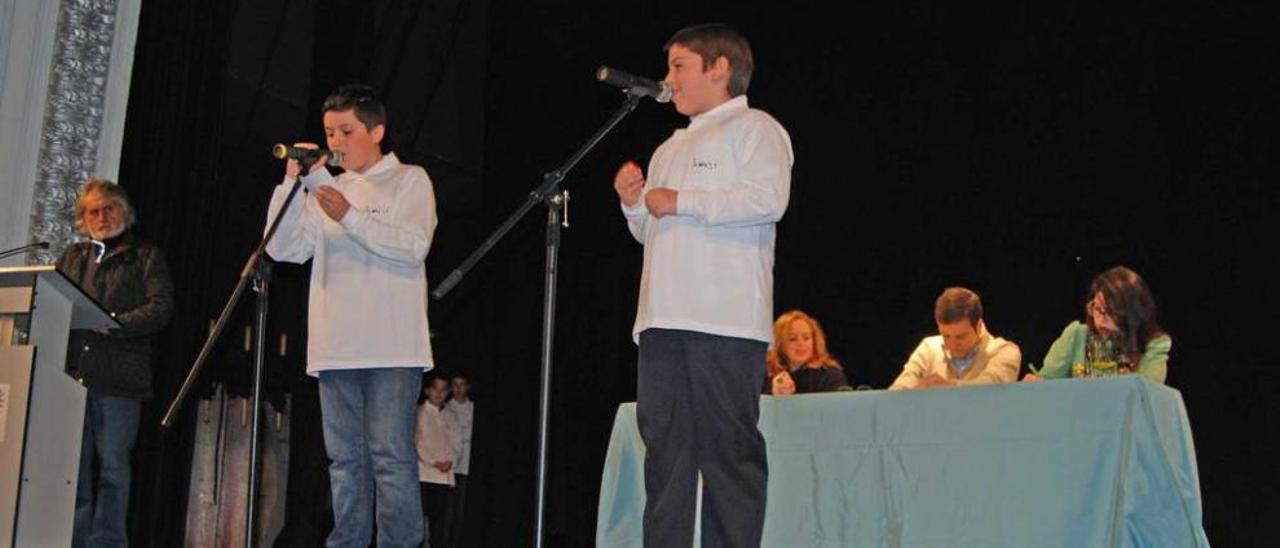 Dos niños cantan los números en el sorteo del año pasado, en Villaviciosa.