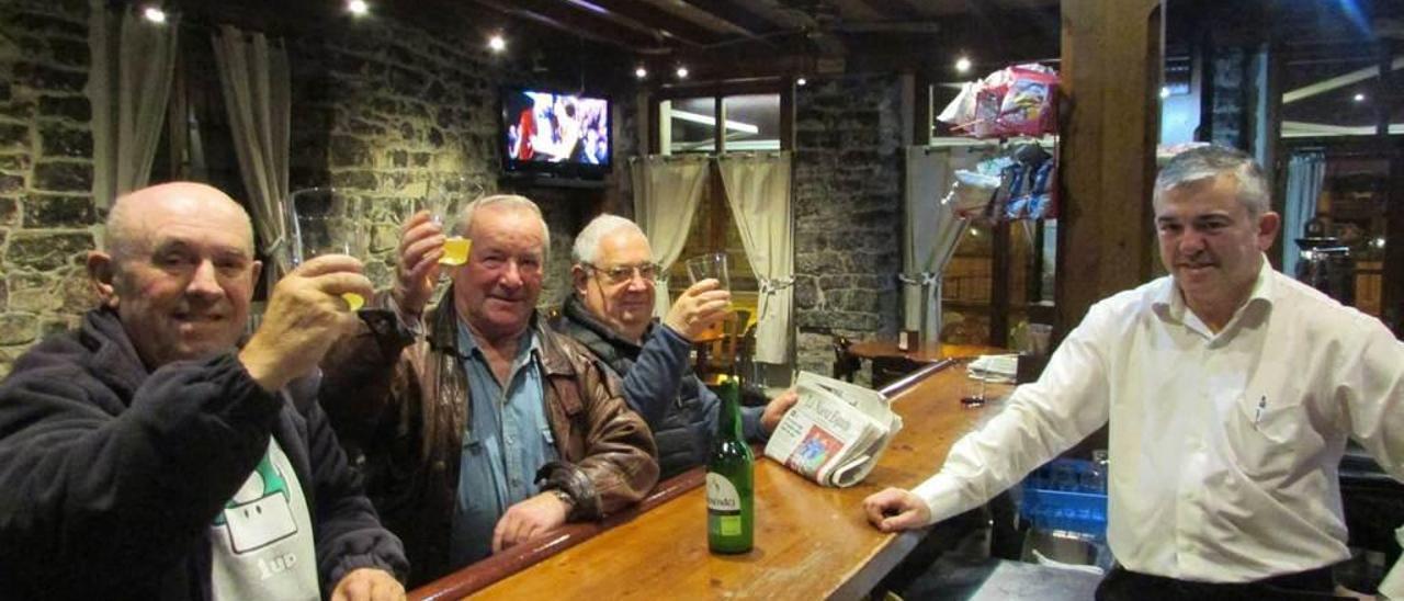 Casto Pérez, Juan Toyos y Ramón Cantora alzan sus vasos de sidra ante Victor Collado, en el restaurante Los Robles, de Cangas de Onís, donde se incluye la sidra como bebida en el menú del dia.