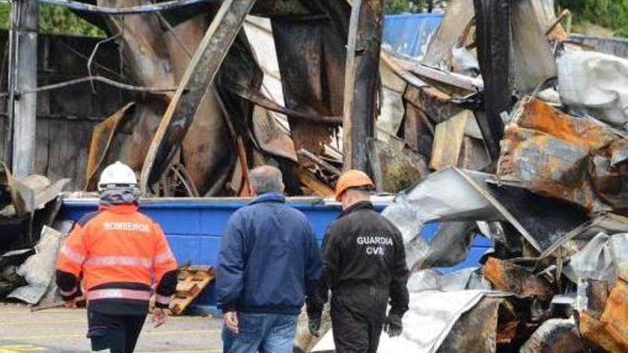 Bomberos y Policía Judicial, ayer, ante las ruinas de la nave que se incendió el lunes. // Gonzalo Núñez