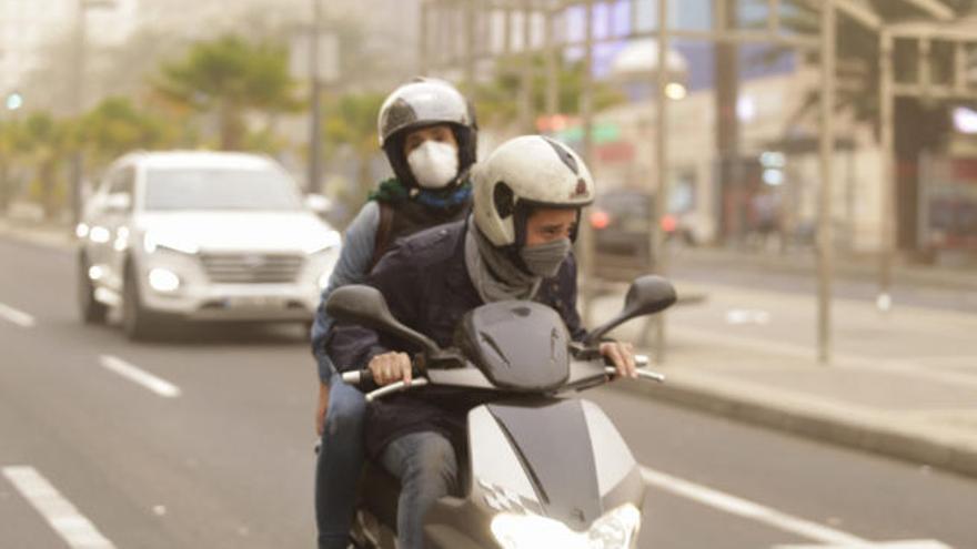 Dos personas en moto y con mascarillas en Santa Cruz.