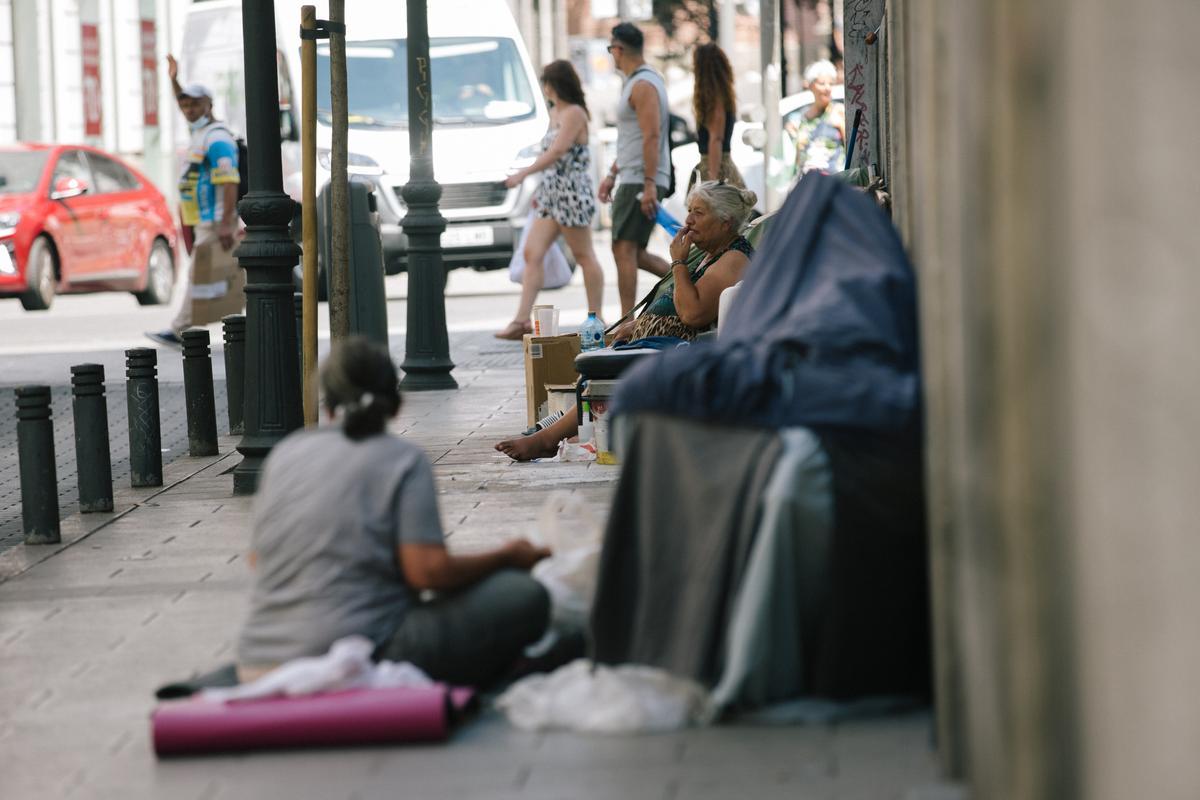 Personas sin techo descansan a la sombra de la calle de la Abada.