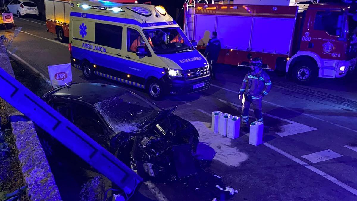 Bomberos y sanitarios frente al coche siniestrado junto a la avenida del Aeropuerto