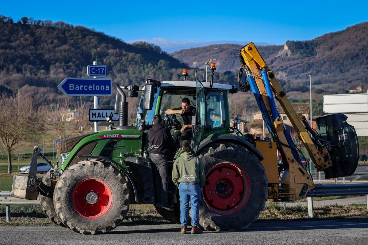 Tres pagesos parlen poc abans d'iniciar la marxa per la C-17 cap a Barcelona