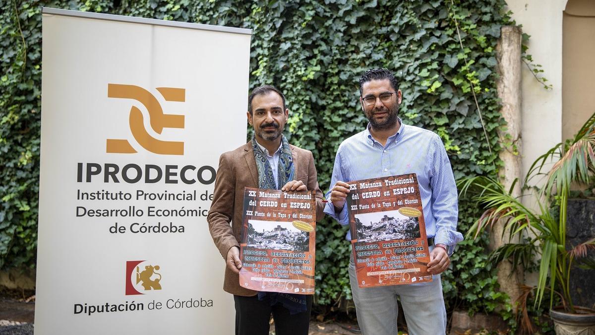 Félix Romero y Florentino Santos muestran el cartel anunciador de la Matanza Tradicional de Espejo.